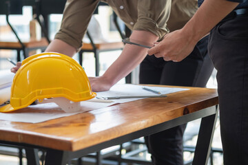 Asian engineers brainstorm and measure to document cost estimates and write floor plans for architectural and engineering designs for houses and buildings.