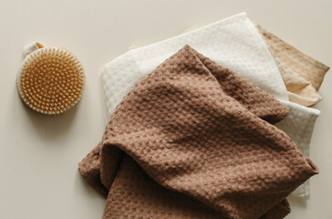 Towels and a washcloth brush lie on a beige surface