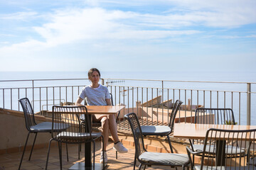 real woman relaxing in a cafe in front of the sea