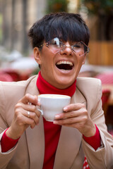 Happy young woman drinking a cup coffee