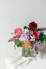 Stylish bouquet on rustic wooden table. Happy Mothers day. Spring lilac, tulips, daffodils...