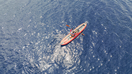 Aerial drone photo of red sport canoe as shot from above in deep blue clear sea