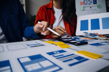 Close up ux developer and ui designer brainstorming about mobile app interface wireframe design on...