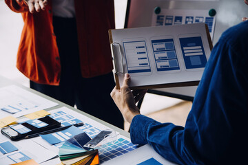 Close up ux developer and ui designer brainstorming about mobile app interface wireframe design on...