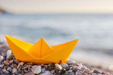 Yellow paper boat on the beach