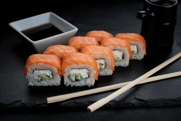 Delicious sushi roll with salmon, cream cheese, and cucumber