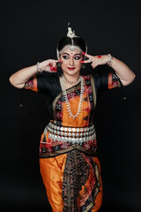 Woman performing Odissi dance in colorful costume. Indian classical dance forms.