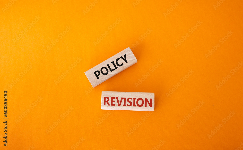 Wall mural Policy revision symbol. Concept word Policy revision on wooden blocks. Beautiful orange background. Business and Policy revision concept. Copy space