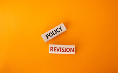 Policy revision symbol. Concept word Policy revision on wooden blocks. Beautiful orange background....