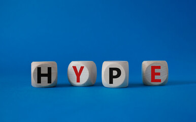 Obraz premium Hype symbol. Concept word Hype on wooden cubes. Beautiful blue background. Business and Hype concept. Copy space.