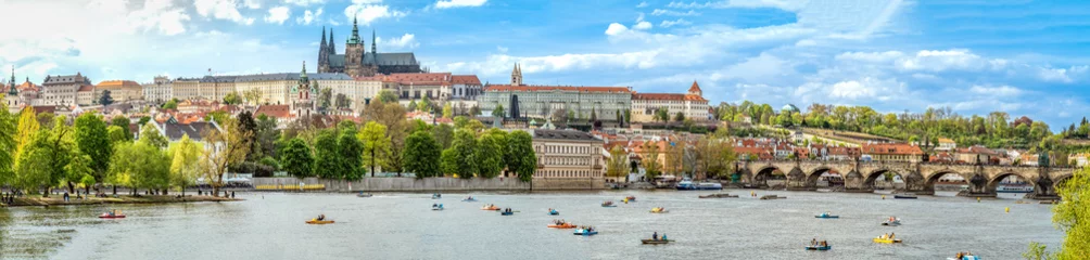 Poster A panoramic view of Prague, the capital of the Czech Republic. View of Prague Castle and Charles Bridge. Summer time, people swim on catamarans. banner © edojob