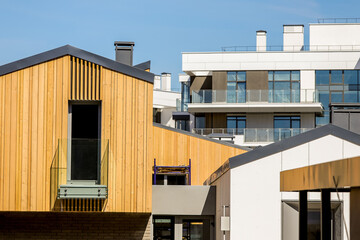 tops of private stylish modern expensive houses against a clear blue sky
