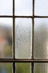 Window in an old constructivist house with frost on the glass
