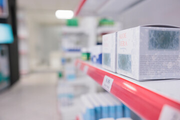 Aloe vera cream standing on pharmacy shelves waiting for customers to come and buy during checkup visit. Drugstore filled with pharmaceutical products and vitamins, supplements. Medicine concept