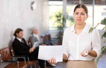 frustrated young female office worker laments over boss's reprimand