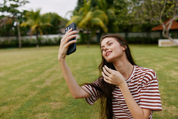 Fototapeta premium blogger woman smiling lifestyle grass tree nature happy palm park person phone