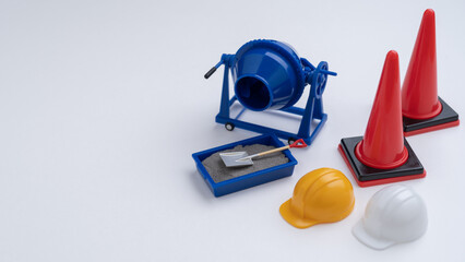 ミニチュアのコンクリートミキサーと三角コーン・建設工事イメージ