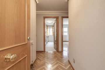 Fototapeta na wymiar Entrance hall of a house with oak parquet flooring and matching wooden doors