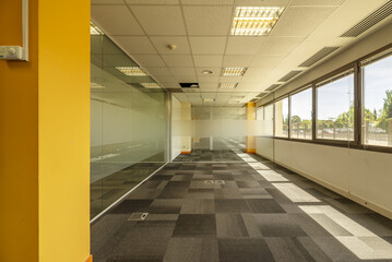 Interior of an office building with open spaces divided with tempered glass partitions