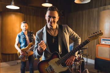 Obraz premium Young musicians practising the song in rehearsal room. High quality photo