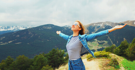Travel concept, happy woman enjoying fresh air mountains raising her hands up on Andorra mountain background - obrazy, fototapety, plakaty
