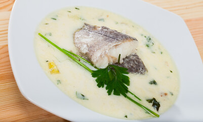 Appetizing thick creamy soup with cod served in soup plate