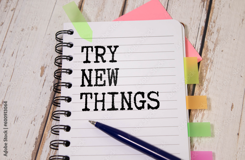 Poster notepad with text try new things in the wooden background