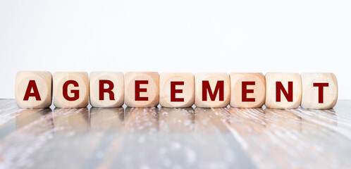AGREEMENT word on wooden cubes on gray background.