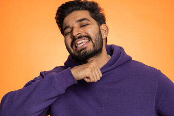 Angry young indian man mimicking knife with finger showing kill gesture of cutting throat....