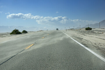 Fototapeta premium Sand Blows Across Desert Road