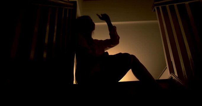 A lonely woman is sitting on the stairs at night . This concept use for symptoms of stress, major depressive disorder (MDD), psychotic symptoms.

