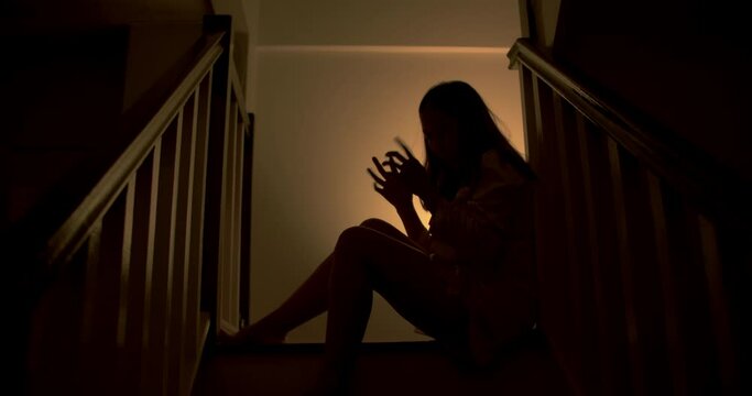 A lonely woman is sitting on the stairs at night . This concept use for symptoms of stress, major depressive disorder (MDD), psychotic symptoms.

