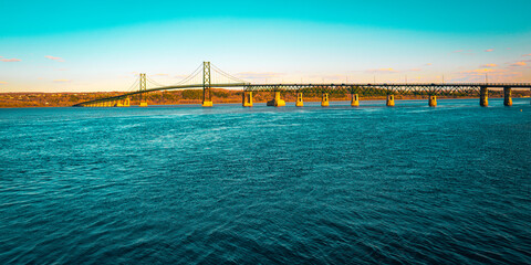 Obraz premium Orleans Island Bridge or Pont de l'Île d'Orléans over the St Lawrence River in Quebec City, Canada, turquoise-colored river water and the sky at dusk