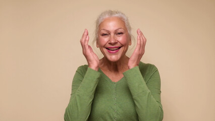 An elderly European woman is laughing loud