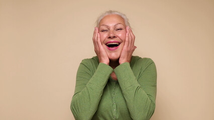 An elderly European woman is laughing loud