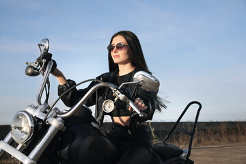 Fototapeta na wymiar Beautiful young woman riding motorcycle on sunny day