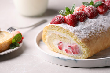 Delicious cake roll with strawberries and cream on light gray table, closeup