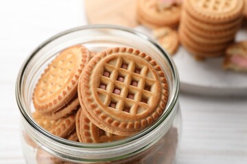 Tasty sandwich cookies with cream in jar, closeup