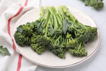 Fresh raw broccolini on white tiled table, closeup. Healthy food