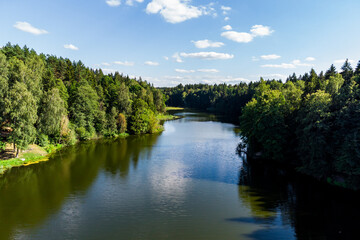 View of a picturesque elongated reservoir with forested banks. Pond on the river Stradalovka, Balabanovo, Russia