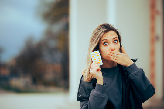 Woman Covering her Mouth Showing Vitamin Pills Tablet. Person feeling nauseated using antiemetic treatment 
