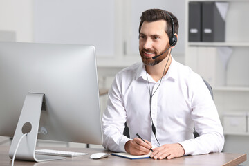 Obraz premium Hotline operator with headset working in office