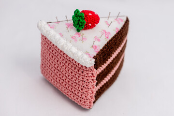 Obraz na płótnie Canvas Chocolate and raspberry cake pincushion with a strawberry on top