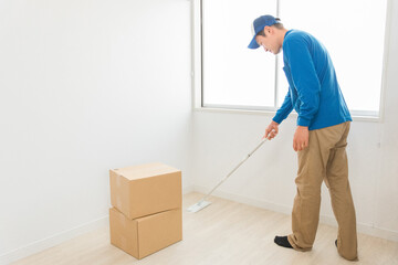 部屋を掃除する引越し業者・清掃業者の男性
