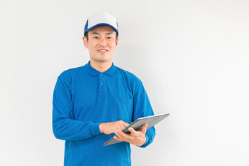 Fototapeta premium パソコンを持つ引越し業者・配達員の男性（引越し・配達・軽貨物ドライバー・宅配・配達員・宅急便） 