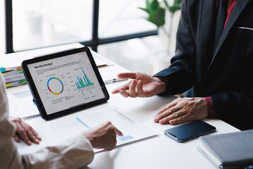 Business people working with financial documents analyzing business financial data together as a team.