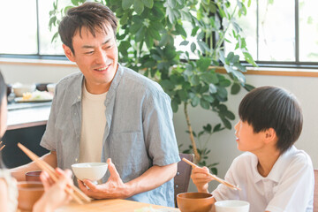 家の食卓で家族と朝食・ご飯を食べる成長期の子供（親子・パパと男の子）
