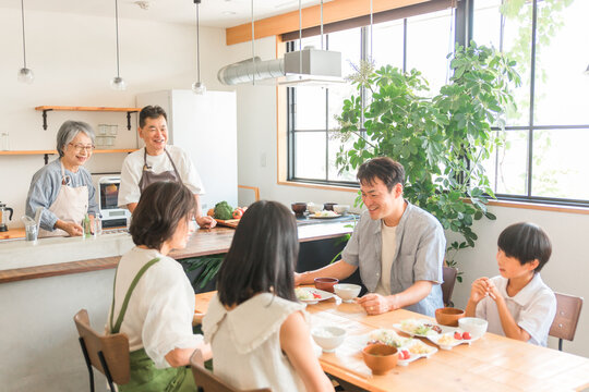 家の食卓で朝食を食べる家族と高齢者夫婦
