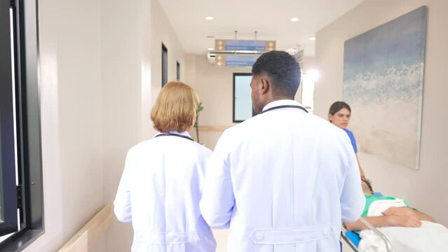 Group of diverse team of doctors walk through the hallway in hospital.