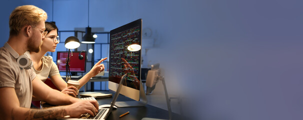 Young programmers working in office at night. Banner for design